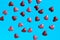 Small red and pink hearts scattered on blue background. Abstract love backdrop.