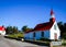 Small red and white church in tadoussac canada on a blue sky background