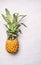 small ripe pineapple on white background wooden rustic, exotic fruit