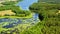 Small river, lake and green forest in Tuchola natural park, Poland from above in summer