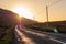 Small road into mountains at sunrise. Sun flare. Warm morning light. Nobody. Connemara, county Galway, Ireland. Travel and tourism