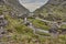 Small road winding through the gap of dunloe, Ireland. Panoramic view of the Gap of Dunloe, Ireland. Small stream flowing through