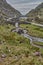 Small road winding through the gap of dunloe, Ireland. Panoramic view of the Gap of Dunloe, Ireland. Small stream flowing through