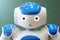 A small robot with a human face and a humanoid body. Blue-and-white robot.