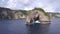 Small Rock Arch Island in the Sea. Nusa Penida, Indonesia. 4K Fly Around Aerial View.