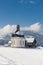 Small round church in snowy alps on sunny winter day