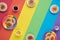 Small round pancakes on white and rainbow plates. Flat lay, top view on rainbow colored paper. Copy-space, place for
