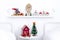 Small round table and shelf decorated for the Holidays with small red house and Christmas tree