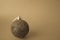 Small round xmas festive New Year`s ball, Christmas toy pasted over with sparkles on a yellow retro sepia background