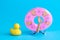 Small rubber duck and doll hand from the water with inflatable pool float minimalistic abstract.