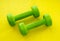 Small rubberized dumbbells 1 kg on a yellow background