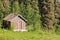 Small rural log cabin hut on clearing in forest