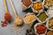 Small sacks with various dried fruit and cereals packed. Two wooden spoons on grey background. Healthy legumes and grains