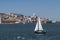 Small sailing boat in the Tagus River with the Lisbon skyline on the background