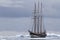 Small sailing ship in Antarctic waters between ice floes and ice