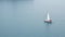 Small sailing yacht sailing in the sea, aerial top view.