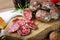 Small salami and red wine glass. Rustic italian snack with chopping board on wooden table.