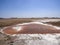 A small salt lake with brown bacteria in central Oman