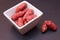 Small sausages on a square bowl on slate