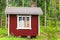 Small Scandinavian red wooden house in forest