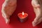 Small scented candle burns in woman hands closeup