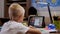 A small schoolboy talks to a teacher via video link during distance learning.