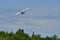 Small seaplane in low flight over trees 2