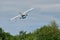 Small seaplane in low flight over trees