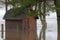 A small shack surrounded by flood water