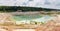 Small shallow turquoise quarry lake in abandoned kaolin pit, panorama
