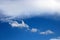 SMALL SHAPELY CLOUDS BELOW A LARGE SOFT WHITE CLOUD IN A BLUE SKY