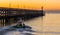 Small ship sailing in the port of Blankenberge, Belgium, the jetty with lighthouse at the belgian coast