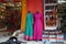 Small shop owner indian man selling shawls, clothing and souvenirs at his store. Colorful traditional Indian costume/outfit for