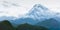 Small silhouette of Gergeti Trinity Church XIV century with a huge Kazbek 5054m mountain. Landscape shot from the Stepantsminda