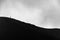 Small silhouette of men climbing on the edge of Etna volcano crater