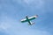 Small single engine vintage colorful airplane in a blue cloudy sky