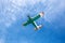 Small single engine vintage colorful airplane in a blue cloudy sky