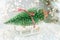 Small sleigh carrying a Christmas tree miniature