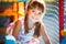 Small smiling girl in dress sitting in colorful soft decorative balls in playroom