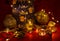 A small snowman figurine stands on a red background surrounded by silver-colored Christmas tree decorations