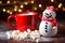 a small snowman is sitting next to a cup of coffee