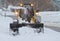 Small snowplow plowing walkway in heavy snowfall
