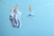 Small socks and pacifier hanging on washing line against color background, space for text.