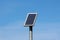 Small solar panel mounted high on top of metal pole