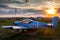 A small sports aircraft parked at the airfield at picturesque sunset