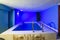 Small square pool in the house with blue light illumination