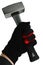 Small square shaped steel hammer held in left hand in black nylon glove with thin red outline, white background