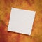 small square sheet of blank white paper against colorful marbled paper