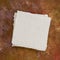 Small square sheet of blank white paper against marbled paper