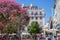 Small square with tourists in centre of Lisbon, Portugal. Colorful landmark of Lisbon. Blooming pink tree with cafe in Lisboa.